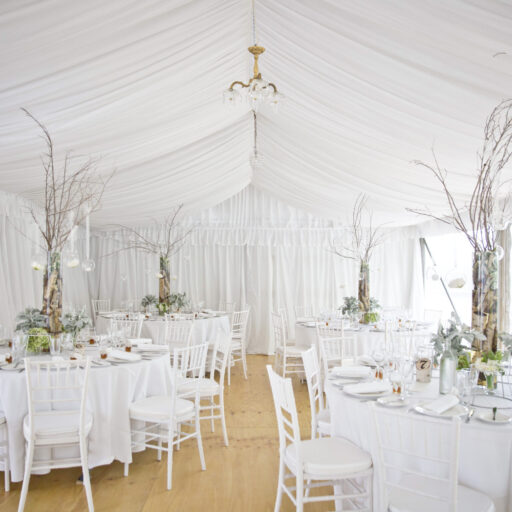 Wedding-6m-x-21m-Pavilion-with-Roof-and-Wall-Lining-Feast-Watson-Flooring-White-Chiavari-Chairs-and-Round-Tables