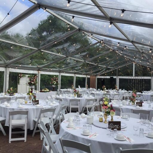 Wedding-10m-x-24m-Clear-Pavilion-with-Festoon-Lighting-Americana-Chairs-Round-Tables-and-White-Linen-at-Beaumont-House