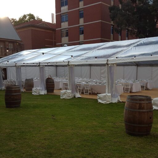 Wedding-at-Armoury-Lawns-10m-x-21m-Clear-Pavilion-with-Americana-Chairs-White-Linen-Wine-Barrels-Feast-Watson-Flooring-and-Festoon-lights