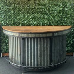 curved-wooden-top-and-corrugated-iron-bar-with-black-metal-frame-detailing-and-foot-rest